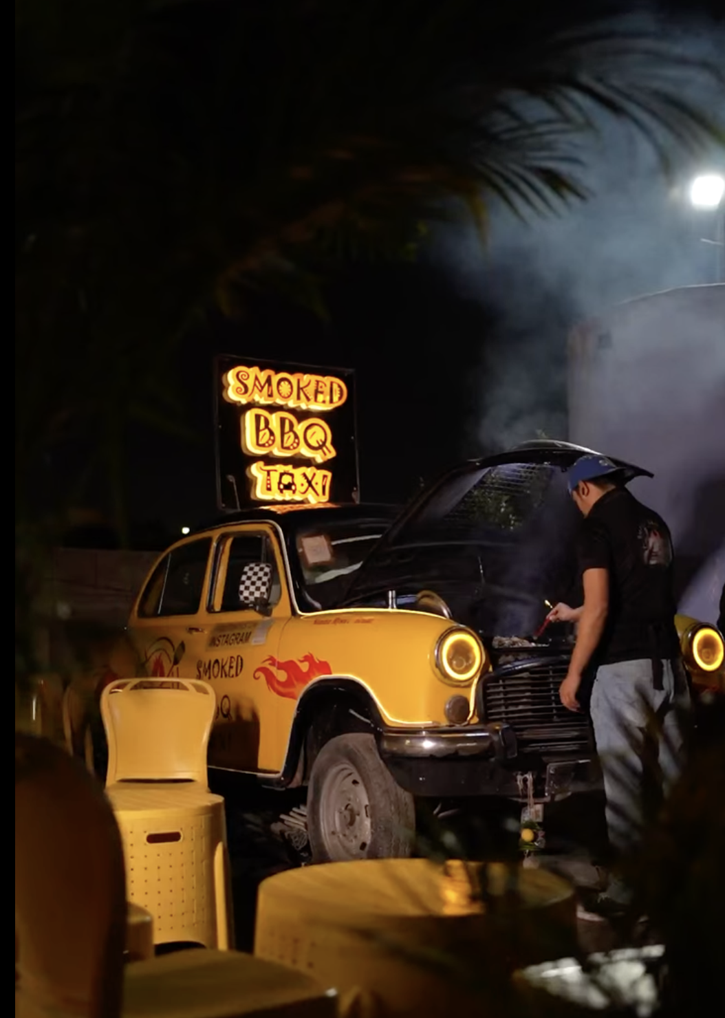 Smoked BBQ Taxi at night with neon sign.
